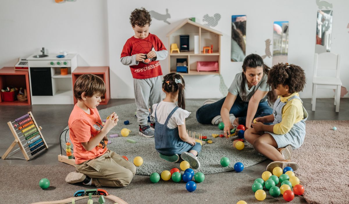 Educatoare și copii de grădiniță la activități în sala de grupă