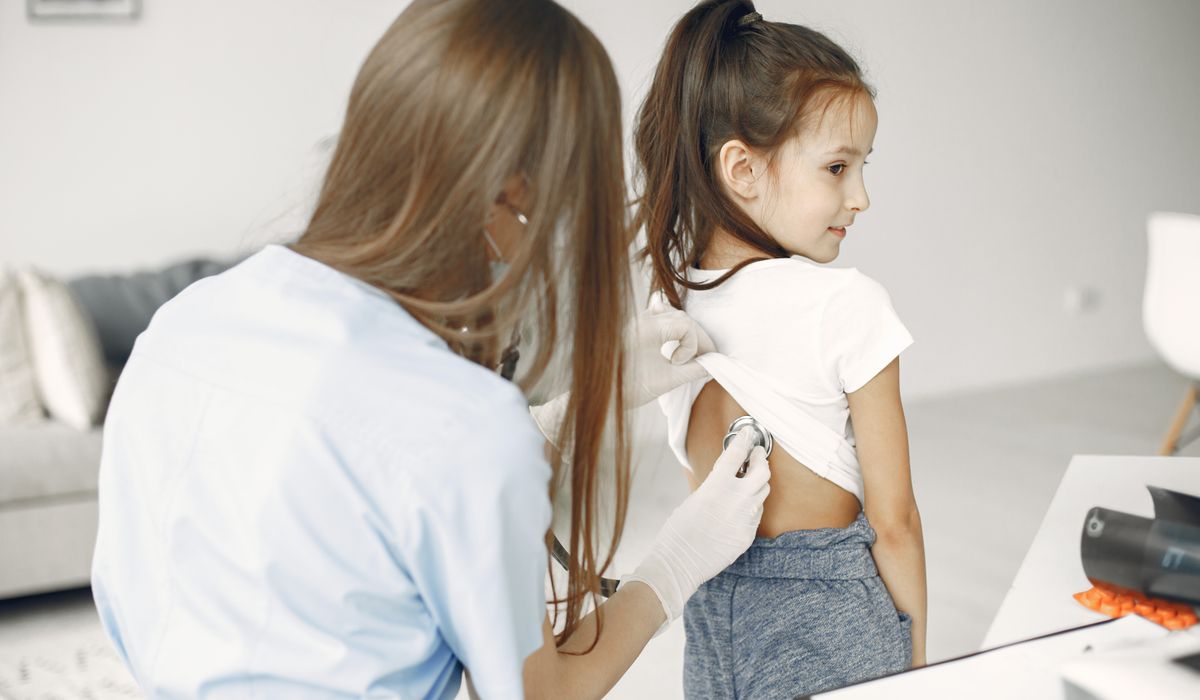 Medic pediatru consultând un copil